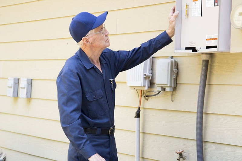 Whole-Home Generator Installation: What to Expect. Senior Adult air conditioner Technician/Electrician services outdoor AC unit and the Gas Generator. He is doing a complete service check up on both of the outside air conditioning units and the stand by generator.